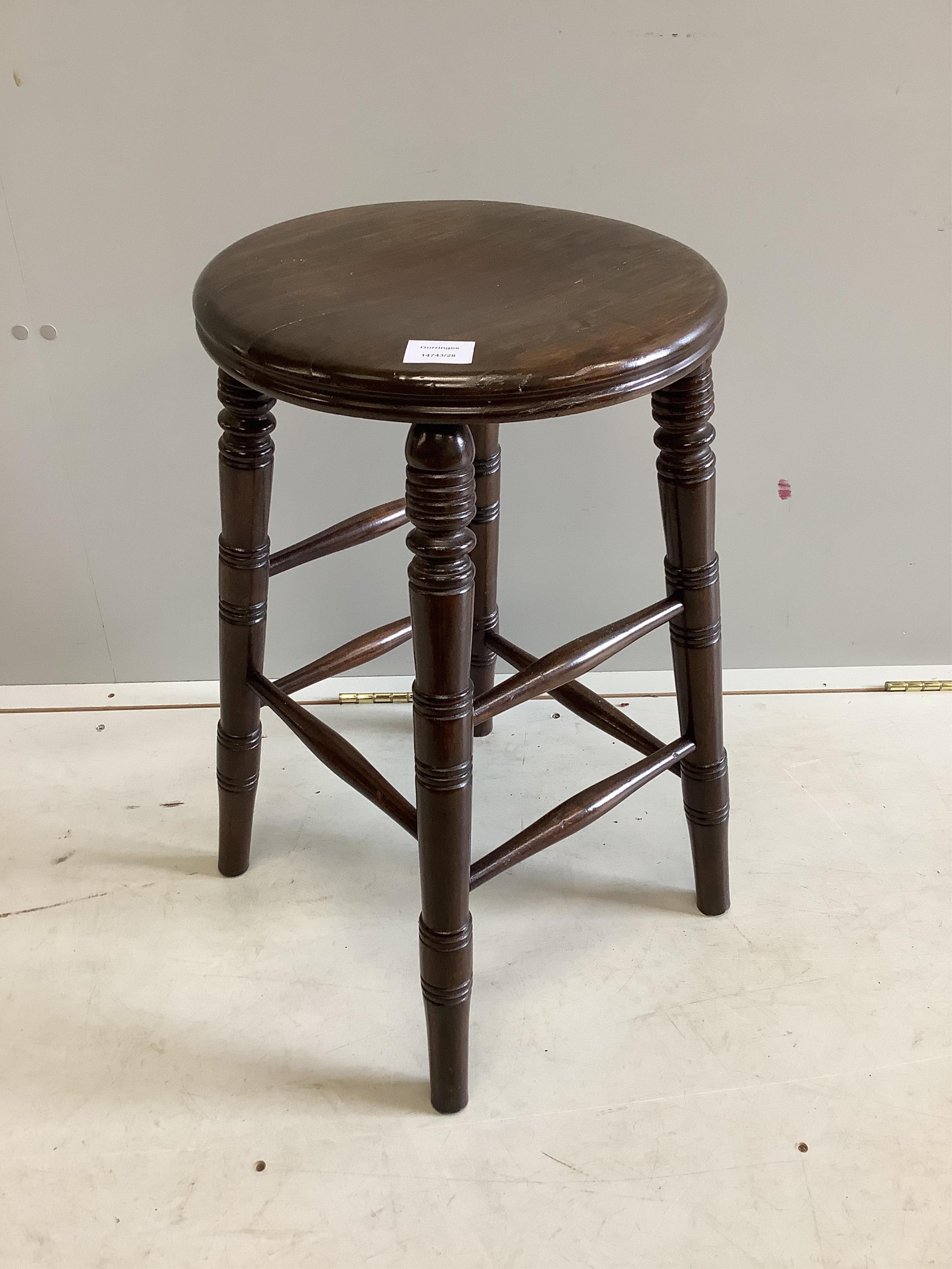A stained beech circular stool, diameter 38cm, height 62cm. Condition - fair